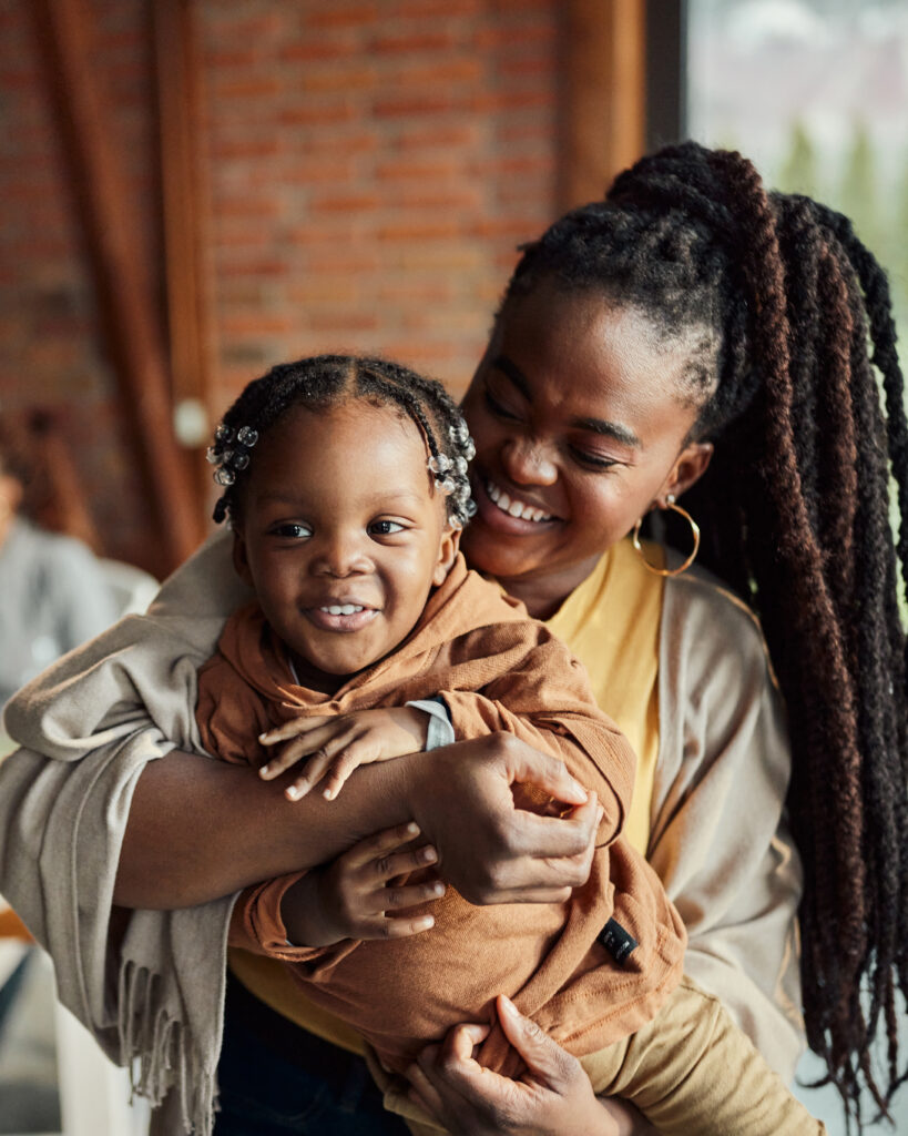 Happy black mother having fun with her baby son at home.